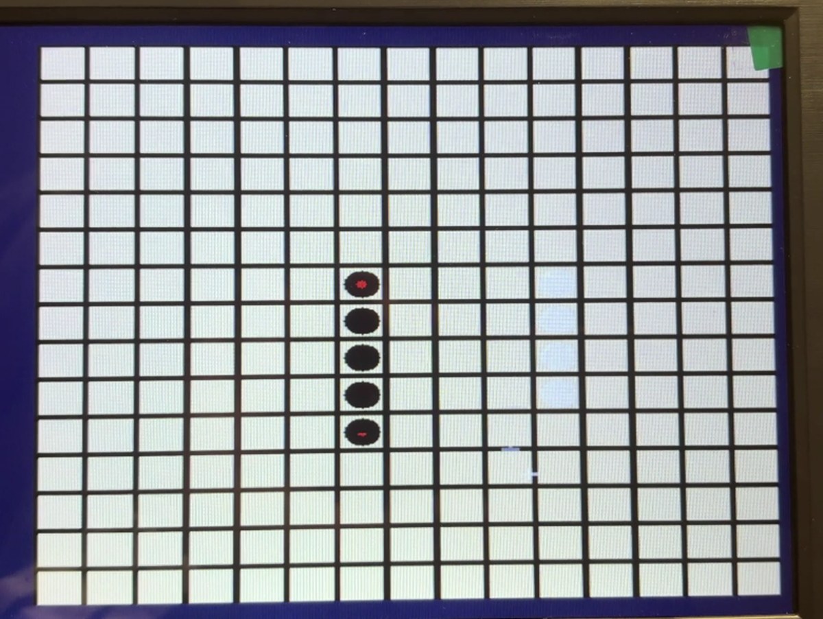 VGA monitor showing a Gomoku board with a winning line of five black stones marked in red